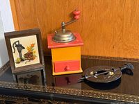 Group view of embroidery, coffee grinder, cast iron spindle