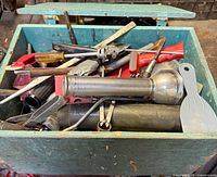 Overall view of green toolbox filled with assorted tools