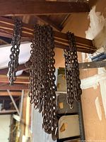 Multiple lengths of forged chains hanging from rafters