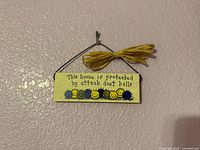 Front view of sign showing text, graphics, wire hanger, raffia bow