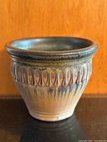 Front view of ceramic planter showing shape, glaze, and relief pattern