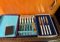 Overall view showing both boxed knife sets and sharpening stone