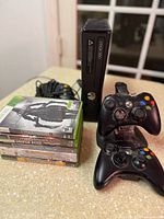Overall lot showing console, controllers, charger, and games