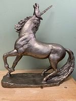 Full left side view of unicorn sculpture showing overall form and base