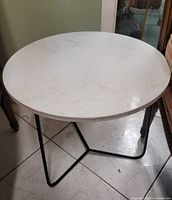 Full view of round marble table with metal base