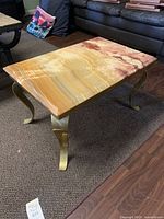 Full view of onyx side table showing stone top and brass legs