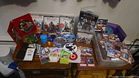 Overall view of PS3 games, trading cards, toys and bin on table