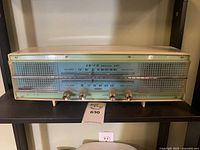 Front view showing dial, knobs and speaker grilles