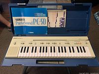 Keyboard with manuals displayed inside open carry case