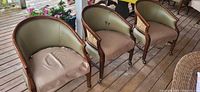 Front view of three matching barrel-back chairs showing overall design and condition