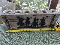 Front view showing cowboy silhouette, six glass votive cups and tape measure for length