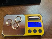 Three 10K gold rings on digital scale displaying 9.26g