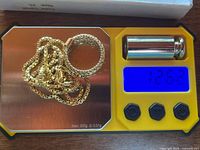 Necklace and ring on digital scale showing 12.62 g total weight