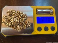 Necklace on digital scale showing weight 21.84 g