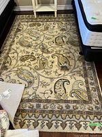 Full view of beige and brown patterned wool area rug on floor