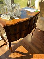 Front and side view of bombe chest showing drawers, legs, veneer and hardware