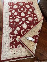 Full view of rug showing maroon field, beige border, fringe