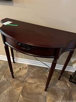 Front view of demi-lune hall table showing drawer and overall finish