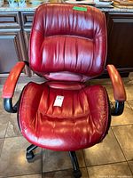 Front view of red executive office chair showing seat, back, arms and base