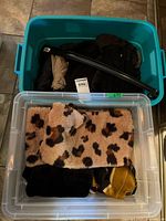 Two bins containing leopard scarf, black item stack, tan umbrella visible