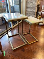 Two nested marble-top side tables showing full design and bases
