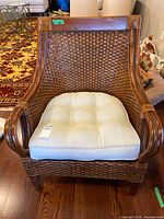 Front view of woven rattan armchair with cushion