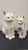 Front view of both ceramic cat figurines