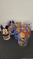 Six of seven tumblers showing Mickey Mouse, Donald Duck and teddy bear designs