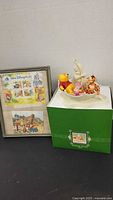 Framed Disney stamp sheet beside Snowbabies box with figurine on top