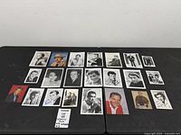 Overview of nineteen signed photographs laid out on two tables
