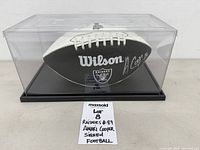 Full view of autographed Wilson Raiders football inside display case
