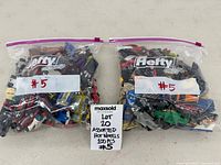 Two Hefty OneZip bags filled with die-cast cars, lot label visible