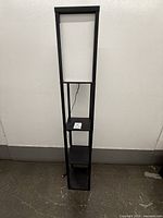 full view of black floor lamp showing shade and three shelves