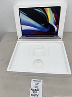 Open Apple MacBook Pro 16-inch box showing lid with laptop image and interior tray