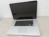 Front view open MacBook Pro showing screen, keyboard and trackpad