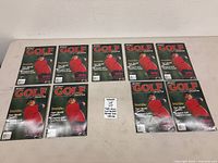 Eight identical Beckett Golf Collector magazines laid out on table