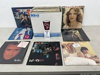 Overall lot showing box full of vinyl records and several albums displayed