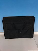 Front view of black art portfolio case showing handles and front pocket