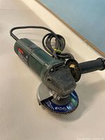 Full view of Bosch corded angle grinder with handle and flap disc