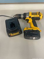 Drill with battery and charger on table