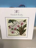 Front of boxed needlepoint kit showing orchid design and branding