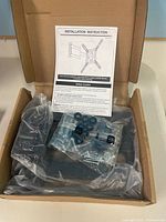 Box opened showing TV wall mount parts bag and instruction sheet