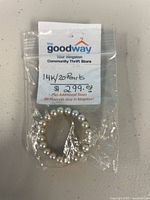 Brooch in retail bag showing pearls and circle form