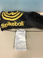 Black Spikeball drawstring bag with instruction sheet visible