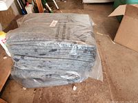 Stack of folded gray moving blankets sealed in plastic