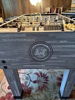 Side and playfield view of Premier Soccer foosball table showing logo, surface wear and player arrangement