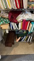 Shelf with multiple fabric bolts and folded pieces in various colors and patterns