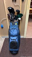 Full view of Ogio blue golf bag standing upright with clubs inside