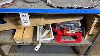 Shelf view showing lumber, paint tray, roller frames, red tray, broom head