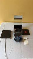 Beats earphones in case, Apple square charging pad with cable, Powerbeats2 box